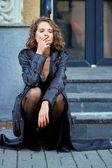 Fototapeta na wymiar Actress sitting on the porch with a cigarette thinking