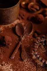 Delicious homemade chocolate preparation process. All kitchen tableware covered with cocoa powder. Intense brown color, aromatherapy. Dark and moody, macro, top view