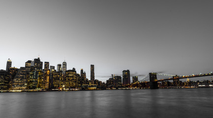 Nigh view of Manhatten and the East River and the Brooklyn Bridge