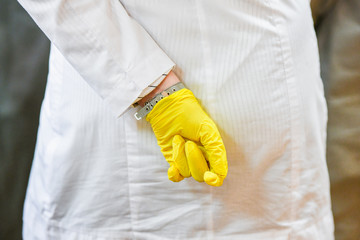 White bathrobe and yellow gloves. Girl with a hand in the back. Unsuitable medical worker. Medical...