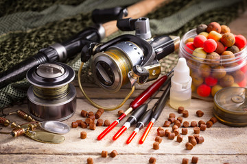 Fishing rods and spinnings in the composition with accessories for fishing on the old background on the table