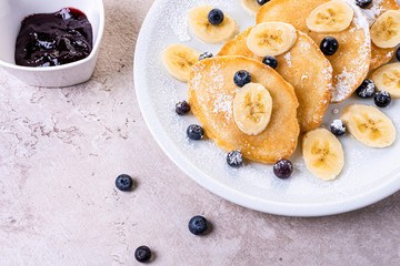 pancakes with banana and blueberries on a white plate, tasty and beautiful