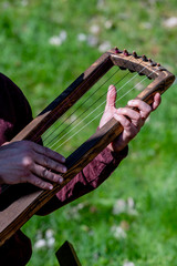 Close-up of a man, playing a musical instrument called jouhikko