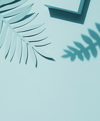 Paper tropical plants leaves on the blue background. Summer concept Top view