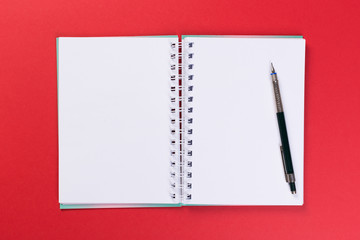 top view of blank open notebook on red background, office equipment, school supplies and education concept