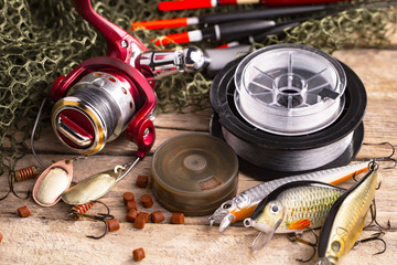 fishing tackle on a wooden table. toned image