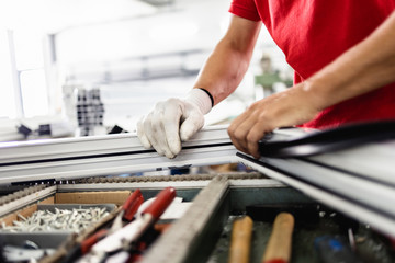 Manual worker assembling PVC doors and windows. Manufacturing jobs. Selective focus. Factory for aluminum and PVC windows and doors production.
