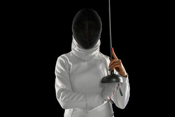 Teen girl in fencing costume with sword in hand isolated on black background. Young female model...