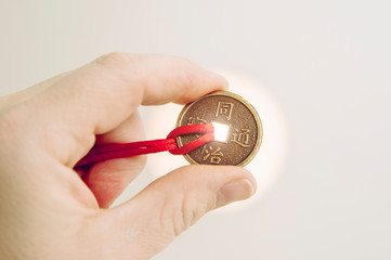 Person hand holding coin used as Feng Shui money cures attracting the energy of wealth and money...
