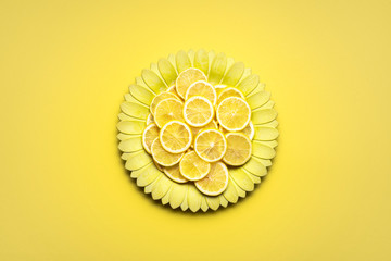 Lemon slices on yellow flower shape plate. Citrus fruits slices