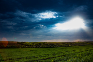 Fototapeta premium Dramatic sunset over fields with clouds