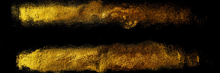 Gold background. Pair of parallel golden traces of acrylic paint with an art brush on a black background.
