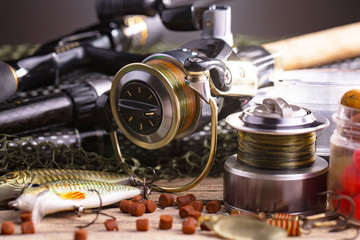 Fishing rods and spinnings in the composition with accessories for fishing on the old background on the table