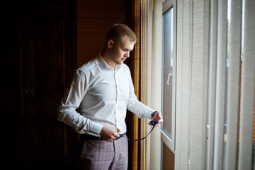 The guy puts a suit on a wedding day