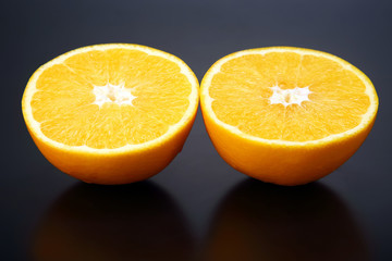 Citrus fruit. Cut orange on dark background