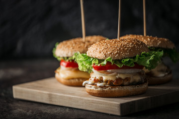 Fresh tasty grilled beef burgers with cheese wood background.