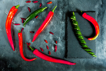 fresh spicy green pepper sliced on slate, cayenne and fresh red peppers