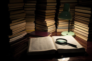 The lamp and the book on the table. Reading a book with lighting the lamp in the dark. Books on wooden table under lamp light