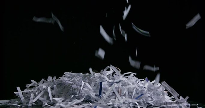 Side view of pile of shredded paper against black slow motion
