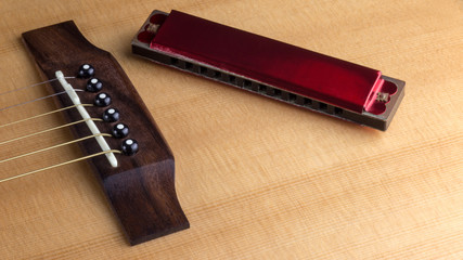 Old Harmonica On Top Of Acoustic Guitar