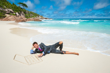 Castaway businessman typing on a tropical beach with a laptop computer hand drawn in smooth sand