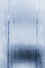 Natural vertical background with drops on glass