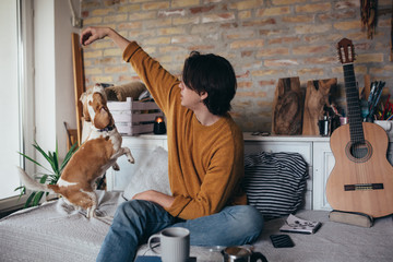 young man playing with his dog at home