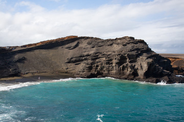 cliff on ocean by green sand beach