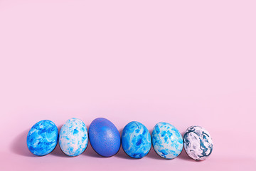 Decorated blue easter eggs on a pink background. Minimal holiday concept. Happy easter background. Creative painting of eggs at home, the idea of simple drawings for coloring