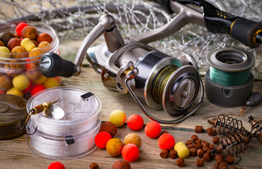 Fishing rods and spinnings in the composition with accessories for fishing on the old background on the table