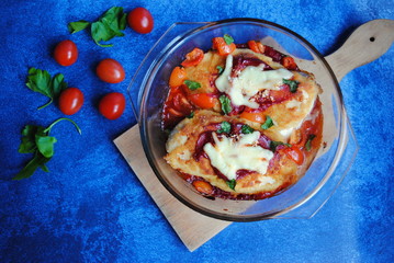 Roasted Chicken Breast with Peeled Tomato Sauce and Cheddar cheese in a Glass bowl - top view