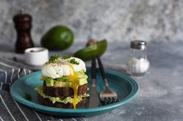 Toasted bread with salad, avocado and poached egg for breakfast. Horizontal focus.