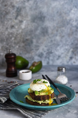 Toasted bread with salad, avocado and poached egg for breakfast. Horizontal focus.