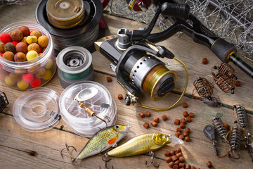 Fishing rods and spinnings in the composition with accessories for fishing on the old background on the table