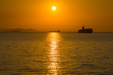 Fototapeta premium 朝焼けの中の海と船と対岸の街DSC1256