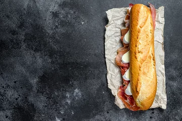 Papier Peint photo Lavable Snack sandwich baguette au jambon serrano jamon, paleta iberica, camembert. Fond noir, vue de dessus, espace pour le texte