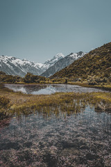 Amazing landscape with small tiny lake and mountains in the background