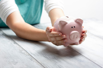 Obraz na płótnie Canvas woman hand putting money coin into piggy for saving money wealth and financial concept.