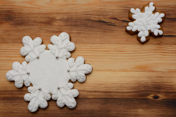 Obraz na płótnie Canvas Two gingerbread cookies in the shape of snowflakes on a wooden Board