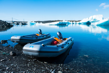  Small inflatable motorized dinghy boats park on the shore of the  ice lagoon in Jökulsárlón,...