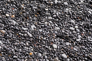 A background of black pebbles and stones on Iceland's black sand beaches of Reynisfjara