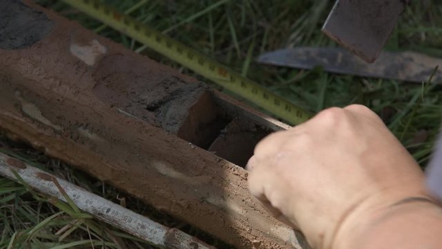 Geologist taking out clay core samples from drill pipe