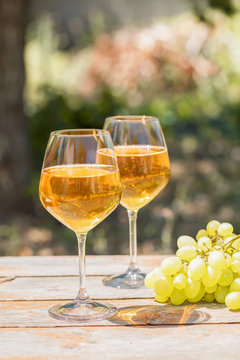 Amber wine in glasses on the nature: still life with cheese, grapes and wine in a rustic style. Georgian national wine or italian wine passito