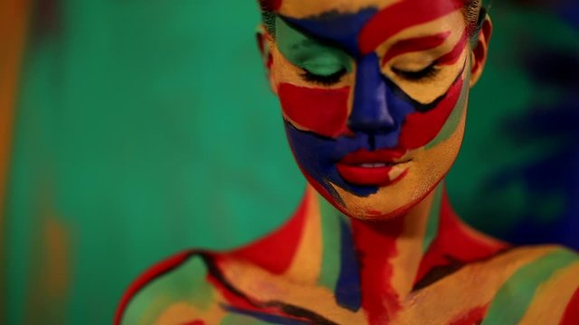 Woman with color face art and body paint. Colorful portrait of the girl with bright make-up and bodyart.