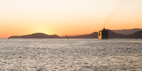 Fototapeta na wymiar A cruise ship leaving the port of Santos, Brazil, during a beautiful summer sunset
