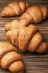 Tasty croissants on wooden table