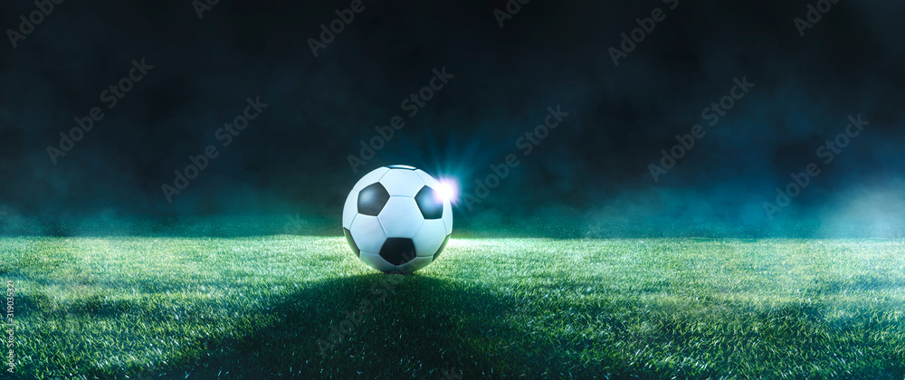 Wall mural football on an illuminated empty sports field at night