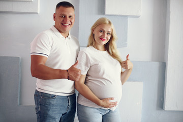 Pregnant woman. Blonde with big belly. Man in a white t-shirt