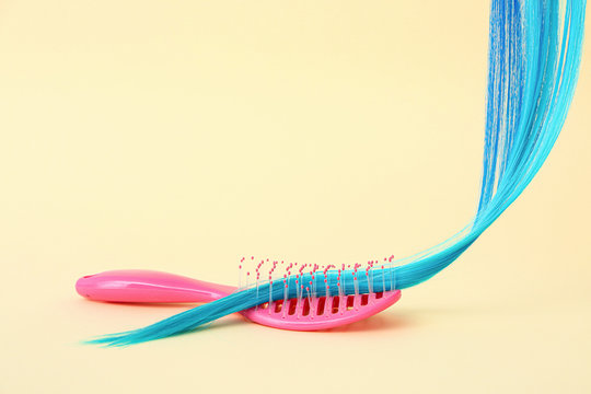 Blue Hair Strand And Brush On Color Background