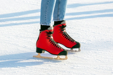 feet in red skates on an ice rink. hobbies and leisure. winter sports